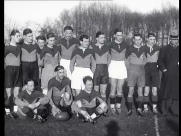 Black-and-white 1933 newsreel frame of one rugby team posed before AAC versus ARVC in Amsterdam; the source does not identify which side this is.