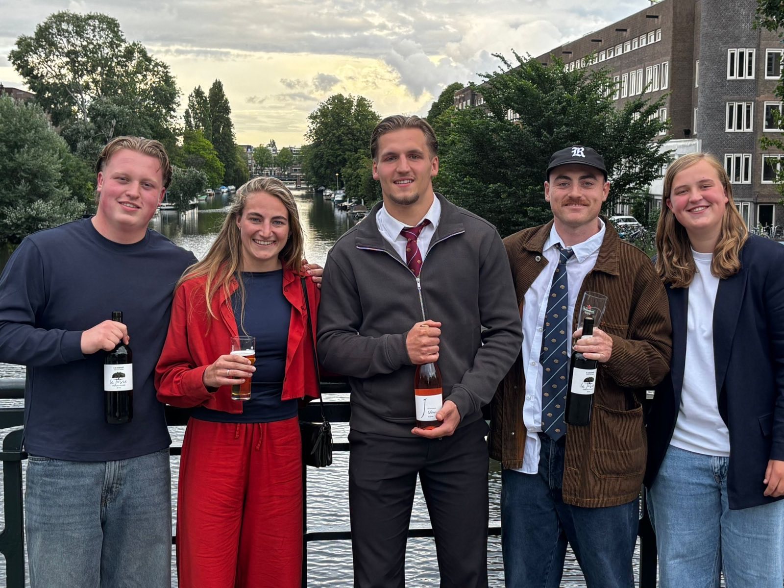 The five players' award winners of 2025/26 stand together on a canal bridge in Amsterdam