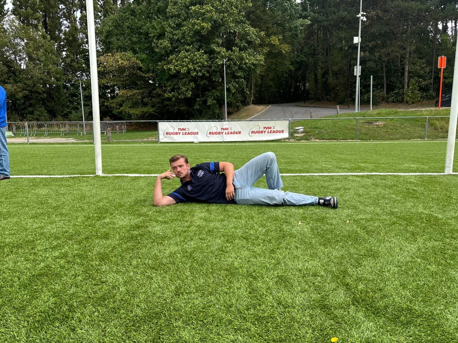 An AAC player in club kit lying on the pitch after the pre-season friendly against Royal Kituro