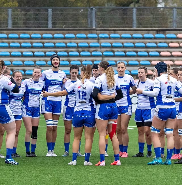 AAC women's squad in a pre-match huddle
