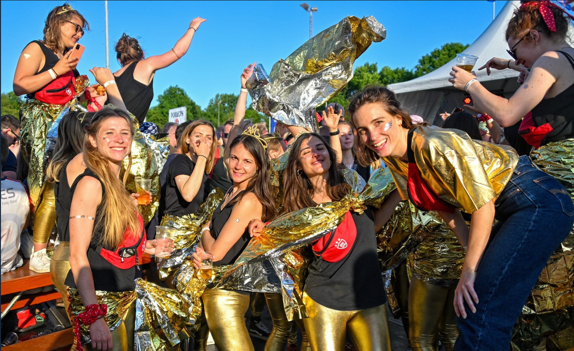 Players in fancy dress and gold capes raise their drinks at the Amsterdam Sevens after-party