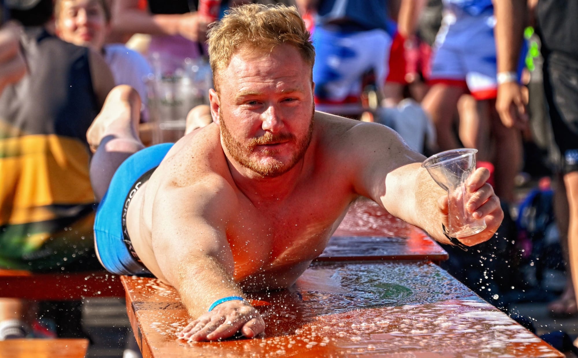 A player slides along a beer-soaked table during the Amsterdam Sevens after-party